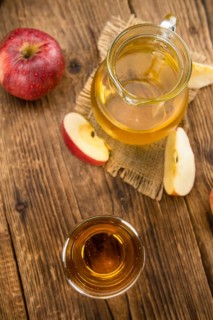 Apple Cider as high detailed close-up shot on a vintage wooden table (selective focus)