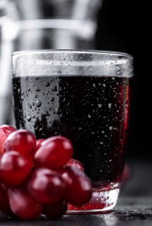Portion of healthy Red Grape Juice on a slate slab (selective focus)