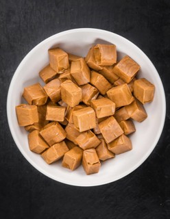 Portion of Caramel candy as detailed close up shot on a slate slab (selective focus)