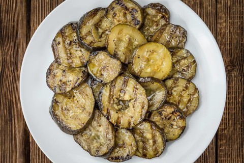 Fresh made Zucchinis (grilled) on an old and rustic wooden table (selective focus, close-up shot)
