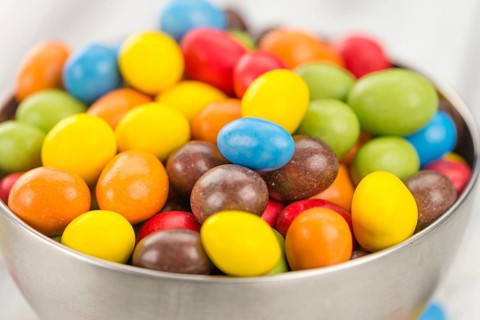 Cocolate coated Peanuts on an old wooden table as detailed close-up shot (selective focus)