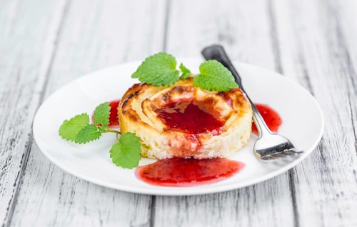Cheesecake with Sauce on an old wooden table as detailed close-up shot (selective focus)