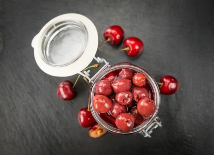 Portion of Preserved Cherries as detailed close up shot on a slate slab, selective focus