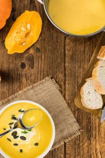 Fresh made Pumpkin Soup (close-up shot) on a vintage background (selective focus)