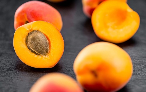 Portion of Fresh Apricots on a rustic slate slab (selective focus, close-up shot)