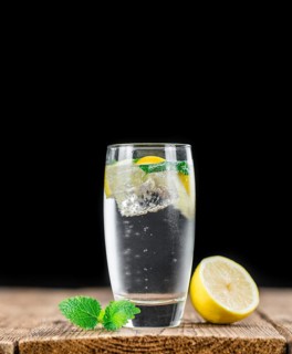 Lemonade (with Balm) as high detailed close-up shot on a vintage wooden table (selective focus)