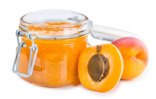 Apricot Jam isolated on white background (selective focus, close-up shot)