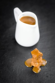 Caramel Sauce on a vintage slate slab (close-up shot, selective focus)