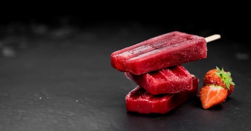 Strawberry Popsicles (close-up shot, selective focus) on a rustic background