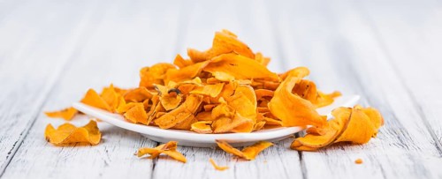 Sweet Potato Chips as high detailed close-up shot on a vintage wooden table, selective focus