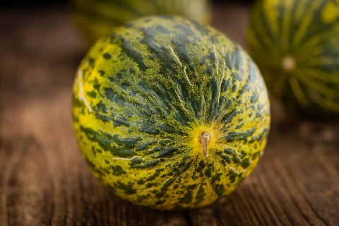 Fresh Futuro Melon as high detailed close-up shot on a vintage wooden table (selective focus)