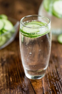 Cucumber Water on rustic wooden background as close-up shot