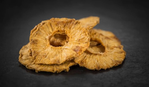 Pineapple rings (dried) on a vintage slate slab as detailed close-up shot, selective focus