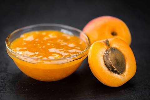 Portion of Apricot Jam as detailed close up shot on a slate slab (selective focus)