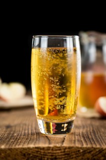 Apple Cider on an old wooden table as detailed close-up shot (selective focus)