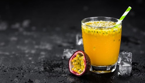 Portion of healthy Maracuja Juice on a slate slab (selective focus)