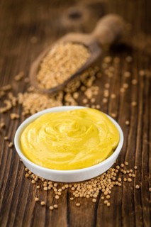 Mustard as high detailed close-up shot on a vintage wooden table (selective focus)