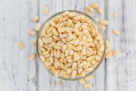 Portion of fresh Pine Nuts (close-up shot, selective focus)
