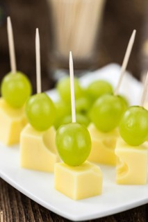 Cheese blocks with grapes as close-up shot (selective focus, partyfood)