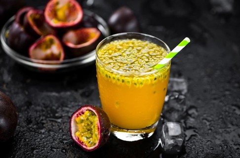 Portion of healthy Maracuja Juice on a slate slab (selective focus)
