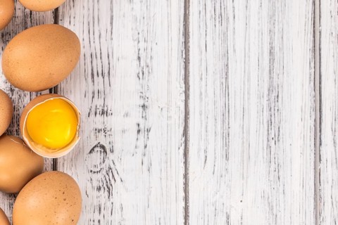 Old wooden table with fresh Raw Eggs (close-up shot, selective focus)