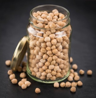 Some dried Chickpeas on a slate slab as detailed close-up shot, selective focus