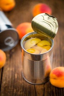Canned Apricots on an old wooden table as detailed close-up shot (selective focus)