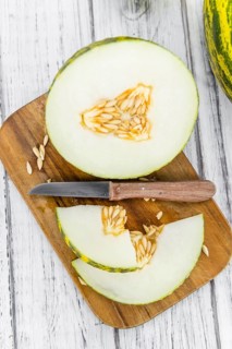 Futuro Melons on an old wooden table as detailed close-up shot (selective focus)