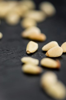 Portion of Pine Nuts as detailed close up shot on a slate slab (selective focus)