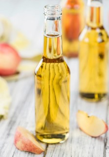 Apple Cider on an old wooden table as detailed close-up shot (selective focus)