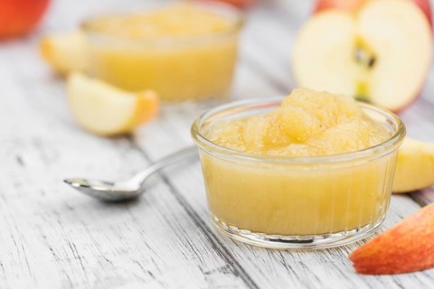 Portion of fresh made Applesauce (selective focus) on a wooden table