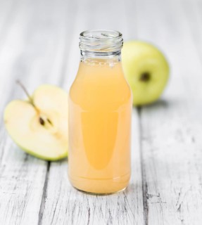 Apple Juice on an old wooden table as detailed close-up shot (selective focus)