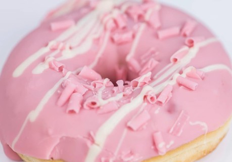Portion of pink glazed Donuts (detailed close-up shot)