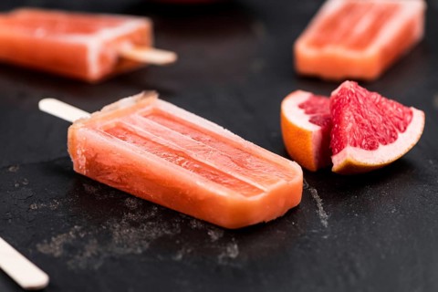 Vintage slate slab with some freshly made Grapefruit Popsicles (selective focus, close-up shot)