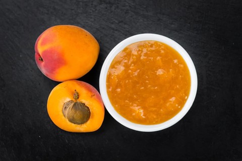 Portion of Apricot Jam as detailed close up shot on a slate slab (selective focus)