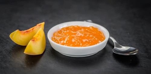 Peach Jam on a vintage slate slab as detailed close-up shot, selective focus