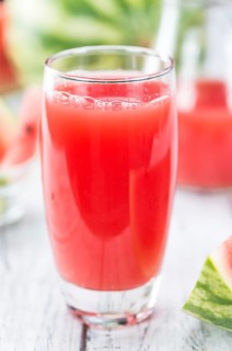 Homemade Watermelon Smoothie on an wooden table (selective focus) as detailed close-up shot