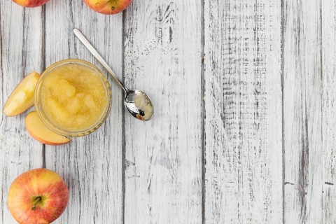 Homemade Applesauce (selective focus, close-up shot) on vintage background with some fresh fruits