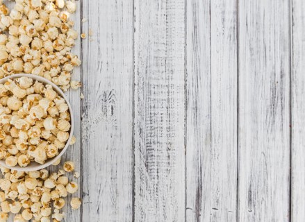 Fresh made Popcorn on a vintage background as detailed close-up shot