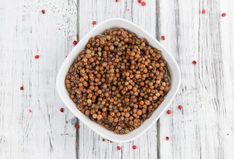 Fresh made Pink Peppercorns (preserved) on an old and rustic wooden table, selective focus,
