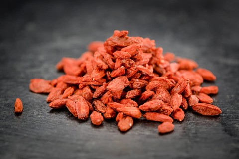 Portion of Dried Goji Berries on a rustic slate slab (selective focus, close-up shot)