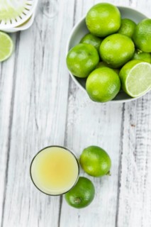 Fresh made Fresh Lime Juice on an old and rustic wooden table (selective focus, close-up shot)