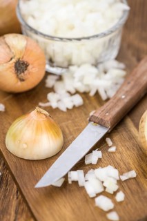 Chopped white onions on an old wooden table as detailed close-up shot, selective focus