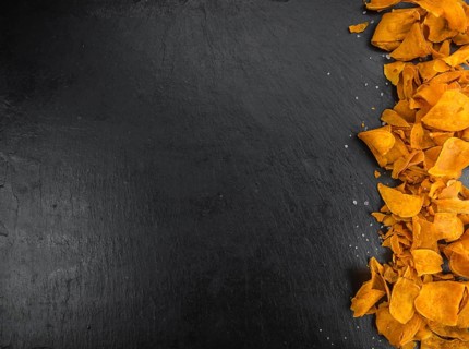 Some fresh Sweet Potato Chips on a vintage slate slab, selective focus, close-up shot