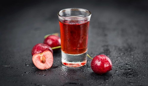 Some Cherry Liqueur on a slate slab as detailed close-up shot, selective focus