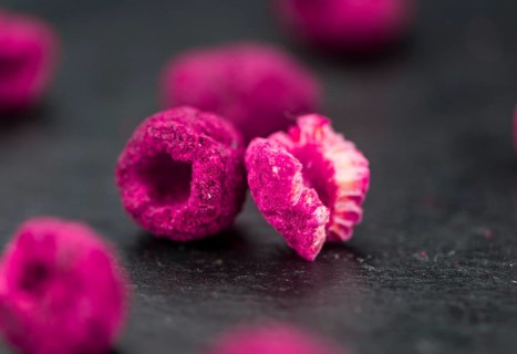 Dried Raspberries on a vintage slate slab as detailed close-up shot, selective focus
