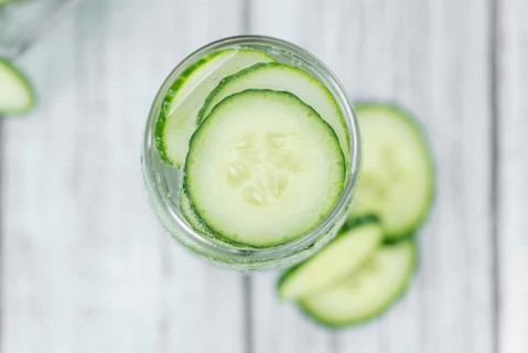 Cucumber Water on rustic wooden background as close-up shot