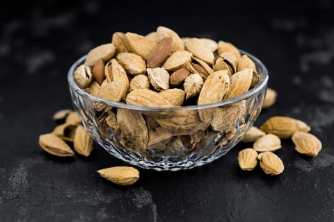 Dark slate slab with roasted and salted Almonds (in the shell)