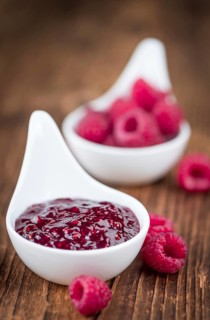 Fresh made Raspberry Jam on an old and rustic wooden table, selective focus, close-up shot