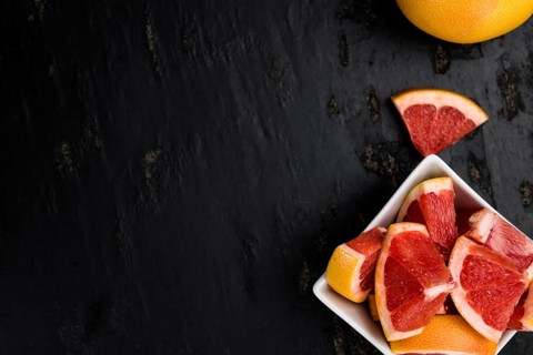 Portion of sliced Grapefruits on an old slate slab (selective focus, close-up shot)